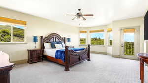 Carpeted bedroom with access to outside, multiple windows, baseboards, and a ceiling fan