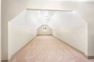 Bonus room featuring carpet flooring, vaulted ceiling, and baseboards