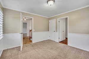Unfurnished bedroom featuring carpet and crown molding