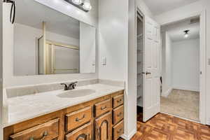 Full bathroom featuring vanity, a stall shower, and baseboards