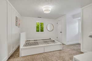 Unfurnished bedroom featuring a textured ceiling and baseboards