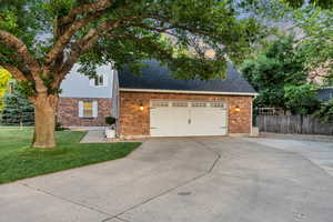 Traditional home with brick siding, concrete driveway, roof with shingles, and a garage