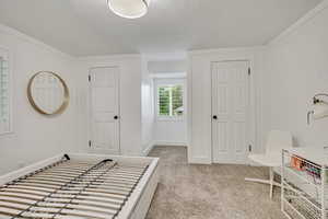 Foyer featuring a textured ceiling, carpet flooring, and baseboards