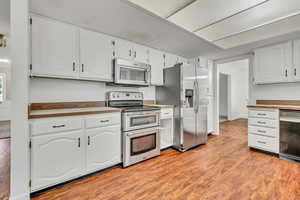 Kitchen featuring appliances with stainless steel finishes, white cabinetry, and light wood finished floors