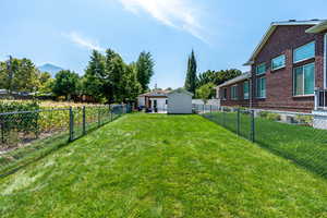 View of yard with an looking toward the patio and storage