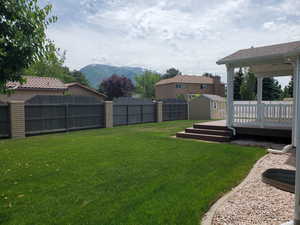 View of yard with a deck with mountain view