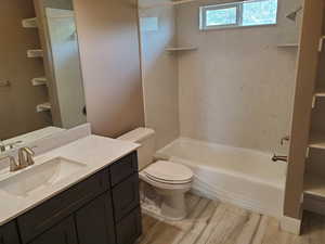 Full bathroom with vanity, wood finished floors, toilet, and bathtub / shower combination
