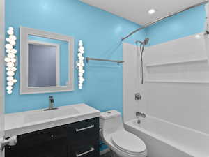 Full bathroom featuring bathtub / shower combination, vanity, and toilet