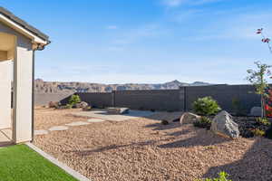 Fenced backyard featuring a patio and a mountain view