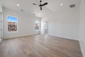 Spare room featuring a ceiling fan, healthy amount of natural light, light wood finished floors, recessed lighting, and vaulted ceiling