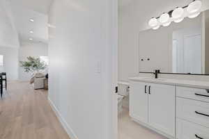 Bathroom with vanity, wood finished floors, and recessed lighting