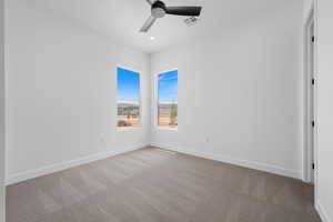 Carpeted empty room featuring ceiling fan, baseboards, and recessed lighting