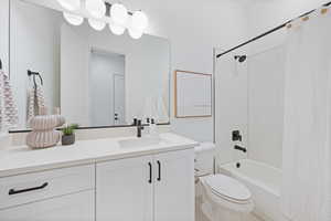 Bathroom featuring shower / bath combination with curtain and vanity
