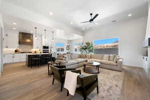 Living room featuring recessed lighting, a chandelier, light wood-style floors, and a ceiling fan