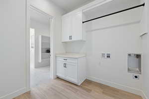 Laundry area featuring hookup for an electric dryer, washer hookup, and cabinet space