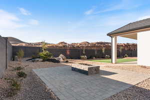 Fenced backyard featuring a patio, a mountain view, and an outdoor fire pit