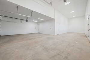 Garage featuring a garage door opener and baseboards