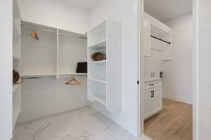 Walk in closet with light marble finish flooring