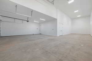 Garage featuring baseboards and a garage door opener