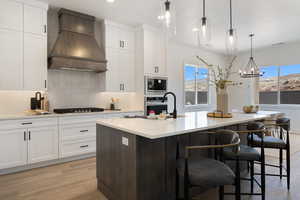 Kitchen featuring custom exhaust hood, plenty of natural light, backsplash, appliances with stainless steel finishes, and recessed lighting