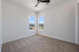 Empty room featuring a ceiling fan and light colored carpet