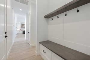 Mudroom featuring light wood-style flooring and recessed lighting