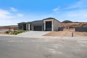 View of front of property with a garage, driveway, stucco siding, and a tile roof