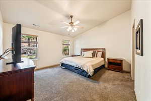 Carpeted bedroom with multiple windows, lofted ceiling, ceiling fan, and baseboards