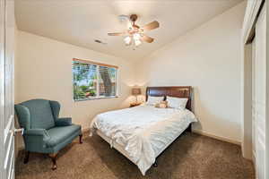 Bedroom with carpet, lofted ceiling, a closet, a ceiling fan, and baseboards