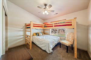 Carpeted bedroom featuring lofted ceiling and ceiling fan