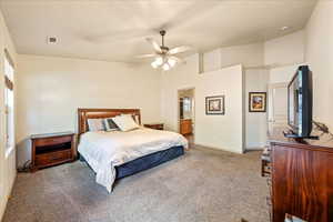 Carpeted bedroom featuring baseboards, ceiling fan, and ensuite bathroom