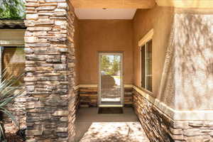 Entrance to property featuring stone siding and stucco siding