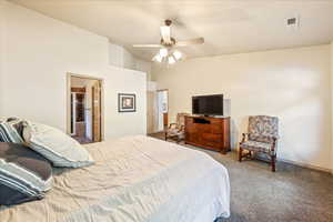 Carpeted bedroom featuring lofted ceiling and ceiling fan