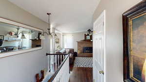 Hall featuring dark wood-style floors and an upstairs landing