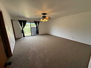 Unfurnished room featuring ceiling fan, light carpet, and baseboards