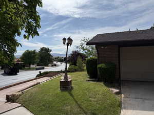 View of green lawn with a garage