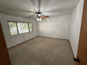 Unfurnished room with a ceiling fan, light colored carpet, and baseboards
