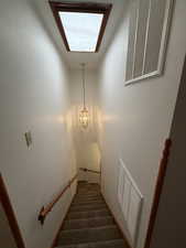 Staircase featuring carpet and a chandelier
