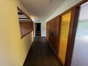 Corridor featuring dark tile patterned flooring