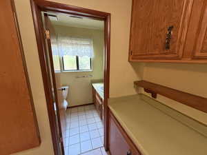 Bathroom with toilet, tile patterned flooring, and vanity
