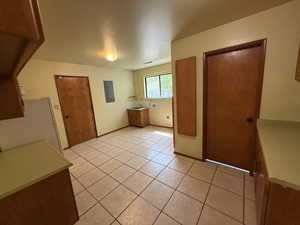 Interior space featuring light tile patterned flooring, washer hookup, and baseboards