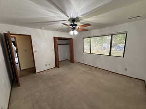 Unfurnished bedroom featuring light colored carpet, baseboards, a ceiling fan, and a closet