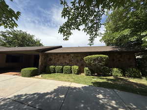 View of home's exterior with stone siding and a patio area