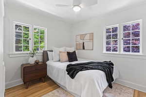 Bedroom with baseboards, ornamental molding, wood finished floors, and ceiling fan