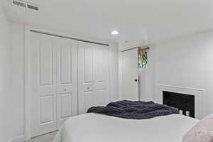 Bedroom featuring a closet, light colored carpet, baseboards, and recessed lighting