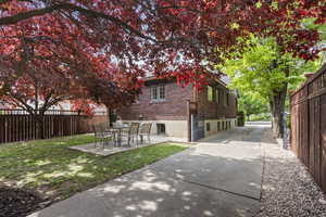 Rear view of house featuring brick siding and a patio area