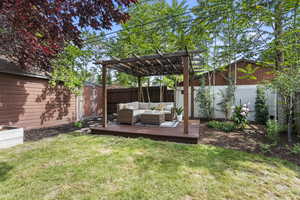 View of yard with an outdoor hangout area, a wooden deck, and a pergola