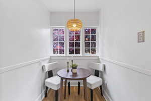 Dining space featuring baseboards, a chandelier, and wood finished floors