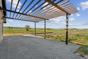View of patio featuring a view of countryside, a pergola, and a mountain view