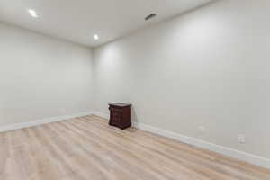 Spare room with light wood finished floors, baseboards, and recessed lighting